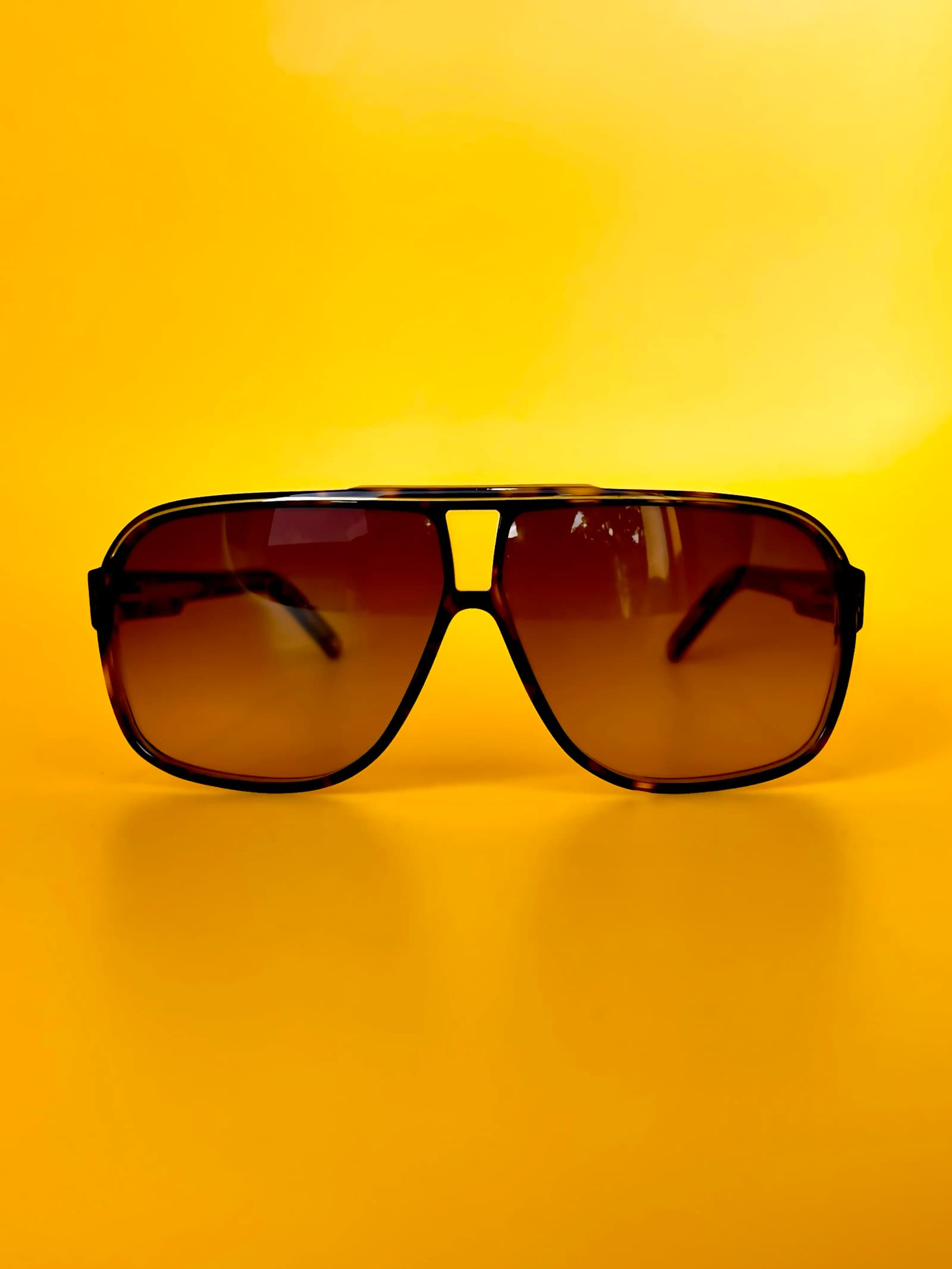Quiet-luxury aviator-style sunglasses with titanium construction representing the Akoni design language