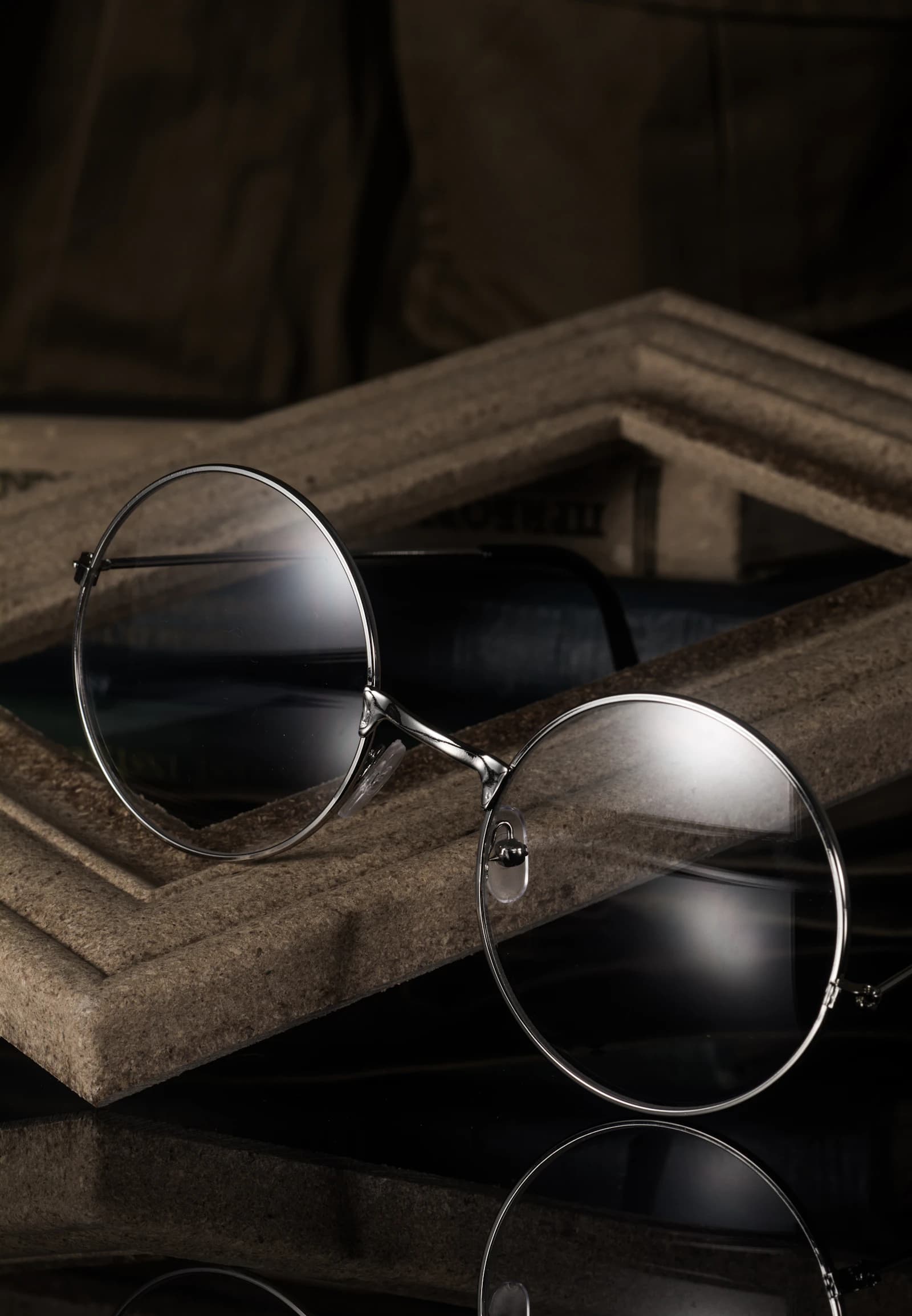 Vintage-inspired round acetate eyewear evoking Jacques Marie Mage cinematic small-batch design on a grey surface