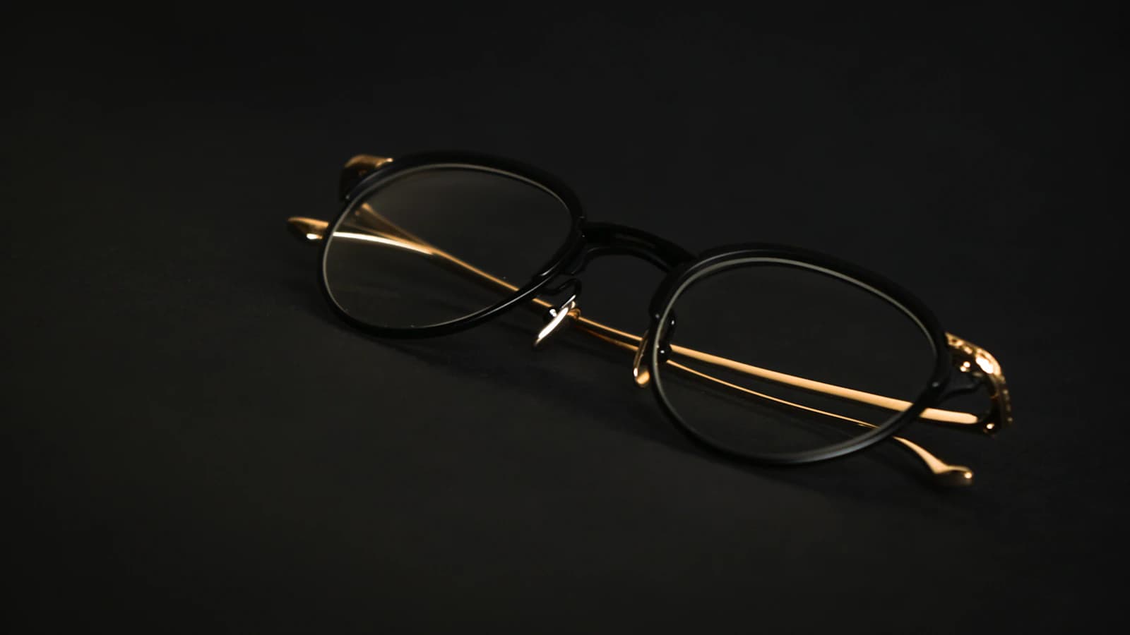 Handmade artisan eyewear evoking Nina Mur Madrid sculptural Spanish design on a textured surface